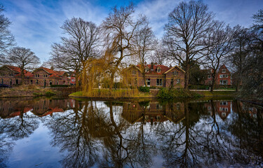Houses and trees are reflected in the river water