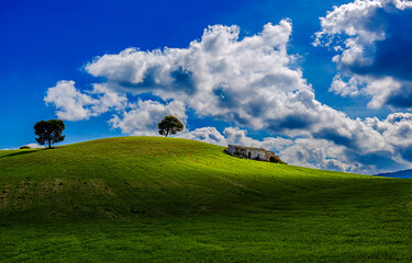 Obraz premium Green hills under clouds in a blue sky. Clouds over green hills. Beautiful summer landscape with green hills