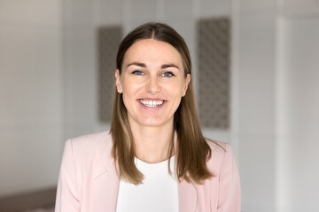 Head shot close up portrait pretty European businesswoman dressed in formal attire looking at...