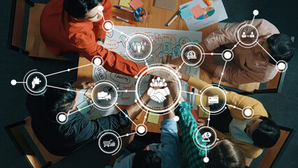 A diverse group of professionals collaborate on a business strategy, utilizing innovative graphics and charts to enhance teamwork and communication in the workspace. Amity