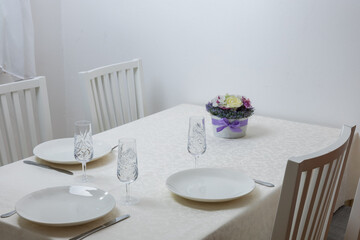 A table set for lunch. Plates on a white tablecloth