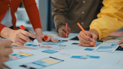A dynamic scene showcasing hands of diverse individuals engaging in a collaborative design process, utilizing colorful markers and paper to create innovative layouts in a modern workspace. SACTR