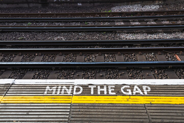 Mind the Gap sign on a train platform warning passengers to be cautious while boarding