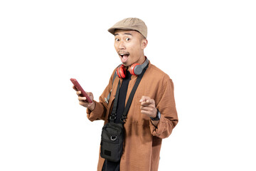 happy young indonesian male traveler pointing at mobile phone contents while traveling, travel concept, isolated on white background