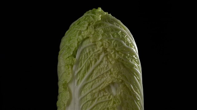 Fresh whole chinese cabbage isolated on a black background, close up, rotates