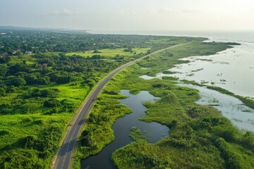 Aerial view of the Sakumono Ramsar Site in Accra, Ghana, showcasing the contrast between lush green wetlands and the adjacent coastal road.