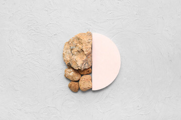 Composition with decorative plaster podium and stones on light background