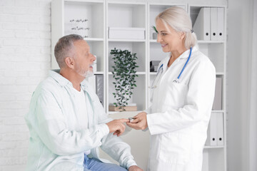 Mature man with pulse oximeter and doctor in clinic