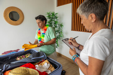 Two women packing and planning for a beach holiday