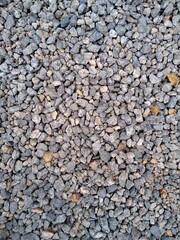Close-up of a rough gravel surface, showcasing various shades of gray and brown stones.
