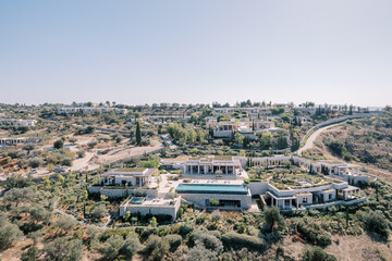 Obraz premium Hotel complex Amanzoe with swimming pools among green trees. Peloponnese, Greece. Drone