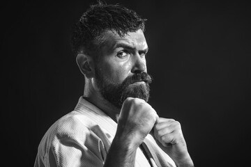 Karate man. Closeup portrait of karate instructor in kimono. Serious bearded karate fighter...