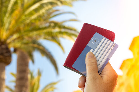 Health insurance in Europe. A holiday destination and a joyfully raised hand with a plastic card guaranteeing treatment in European Union countries