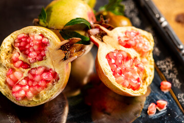 Pomegranates, beautiful freshly picked pomegranates on a wonderful tray on a rustic surface,...
