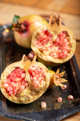 Pomegranates, beautiful freshly picked pomegranates on a wonderful tray on a rustic surface, selective focus