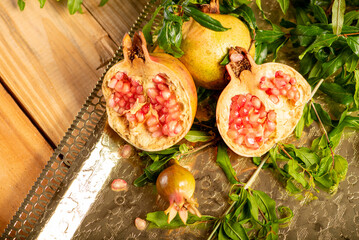 Pomegranates, beautiful freshly picked pomegranates on a wonderful tray on a rustic surface,...