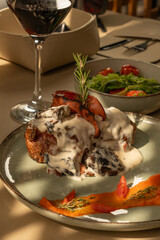 Juicy beef rib eye steak with mushroom sauce and tender vegetables on a table in an elegant restaurant.