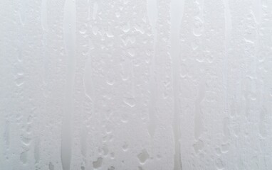 Water Droplets Forming Vertical Streaks on Window Pane