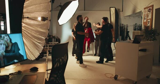 People, photographer and photoshoot success in studio, team celebration and production goals. Staff, model and filming bts with high five of catalog achievement, beauty magazine and creative industry