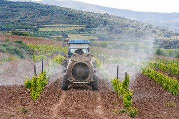 tractor spraying vineyards with chemicals