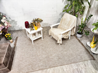 Cozy interior living space with a chair, side table, and potted plants during bright daylight