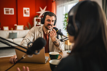 man host interviewer woman guest record podcast at home studio