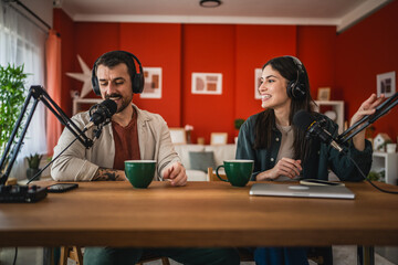 two young adult hosts record together podcast in home studio