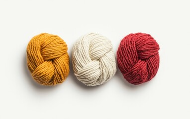 Three Balls of Yarn in Mustard Yellow Off White and Burgundy on White Background