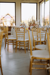 Elegant Dining Setup with Golden Chairs and Floral Centerpieces