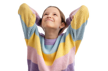 A young girl with a joyful expression, wearing a colorful striped sweater, looking up with her...
