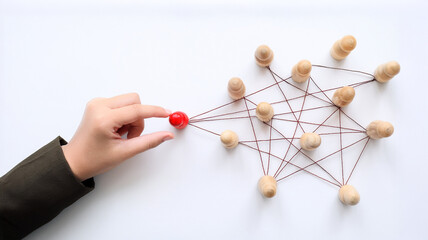 Obraz premium a hand connecting a red wooden doll to a network of other dolls. This image shows the importance of communication, relationships, and teamwork