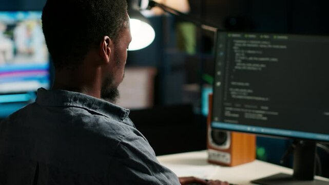 Male developer entering binary data on terminal panel while writing html code. Software engineer working on troubleshooting with programming language, internet and server security. Camera B.