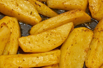 Baked potato slices with seasoning mixture. Close-up.
