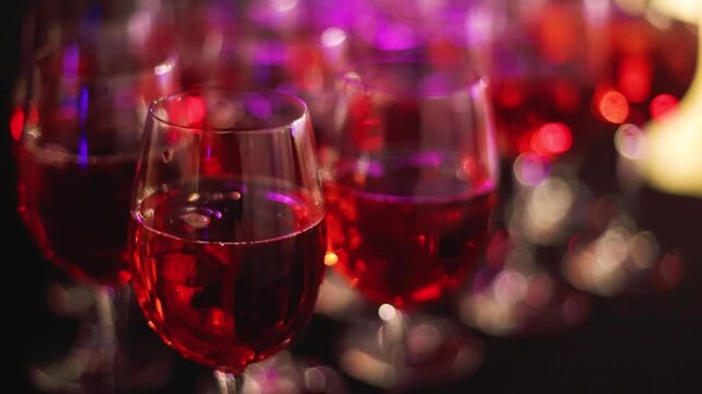 Alcohol setting on catering banquet table, row line of orange red coloured aperitif alcohol cocktails on party, negroni, spritz and others on bar counter, selection of liquor beverages on event