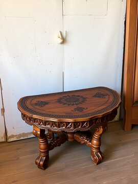 A rustic, hand-carved wooden semit table with intricately inlaid patterns and ornate legs sits against a distressed