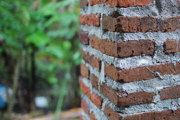 The appearance of a red brick wall without cement coating, a vintage building concept.