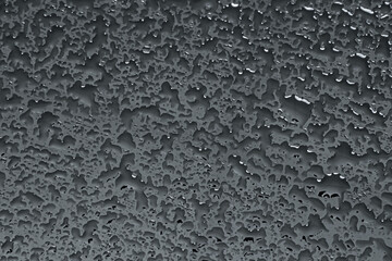 Water drops on dark grey glass surface, top view