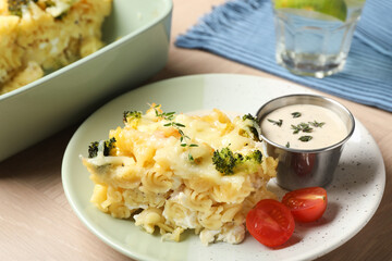 Tasty pasta casserole with cheese and broccoli served on wooden table, closeup