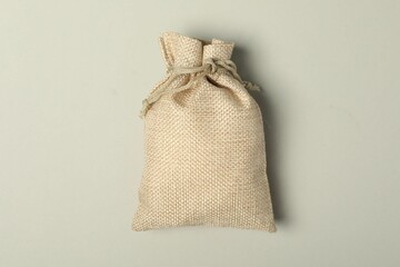 Beige burlap sack on light gray background, top view
