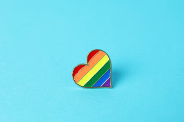 Heart shaped badge in LGBT colors on light blue background