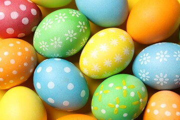 Beautiful decorated Easter eggs on yellow background, flat lay