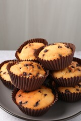 Delicious muffin with chocolate chips on table, closeup