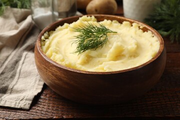 Delicious mashed potato with dill served on wooden table, closeup
