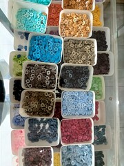 several types of shirt buttons in a glass display case