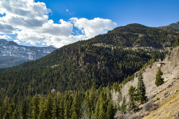 Mountain ranges and trees on a clear partly-cloudy sunny day in southwestern Colorado, USA