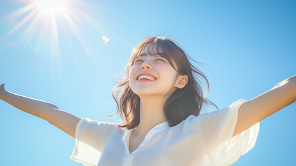 青空の下で両手を広げる笑顔の女性