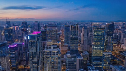 Naklejka premium Cityscape at Dusk: Aerial view of a sprawling city with illuminated skyscrapers and buildings silhouetted against a vibrant dusk sky, showcasing the urban landscape and architectural marvels.