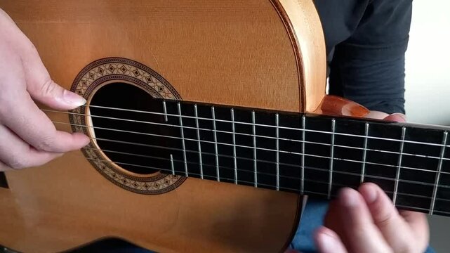 Play A guitar peice by a guitarist from close up angle
