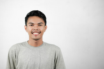 Fototapeta premium Happy smiling asian man, wearing gray shirt, young man isolated on white background