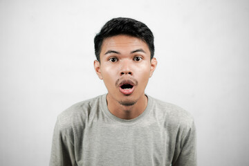 Asian man shows shocked expression with wide eyes and gaping mouth